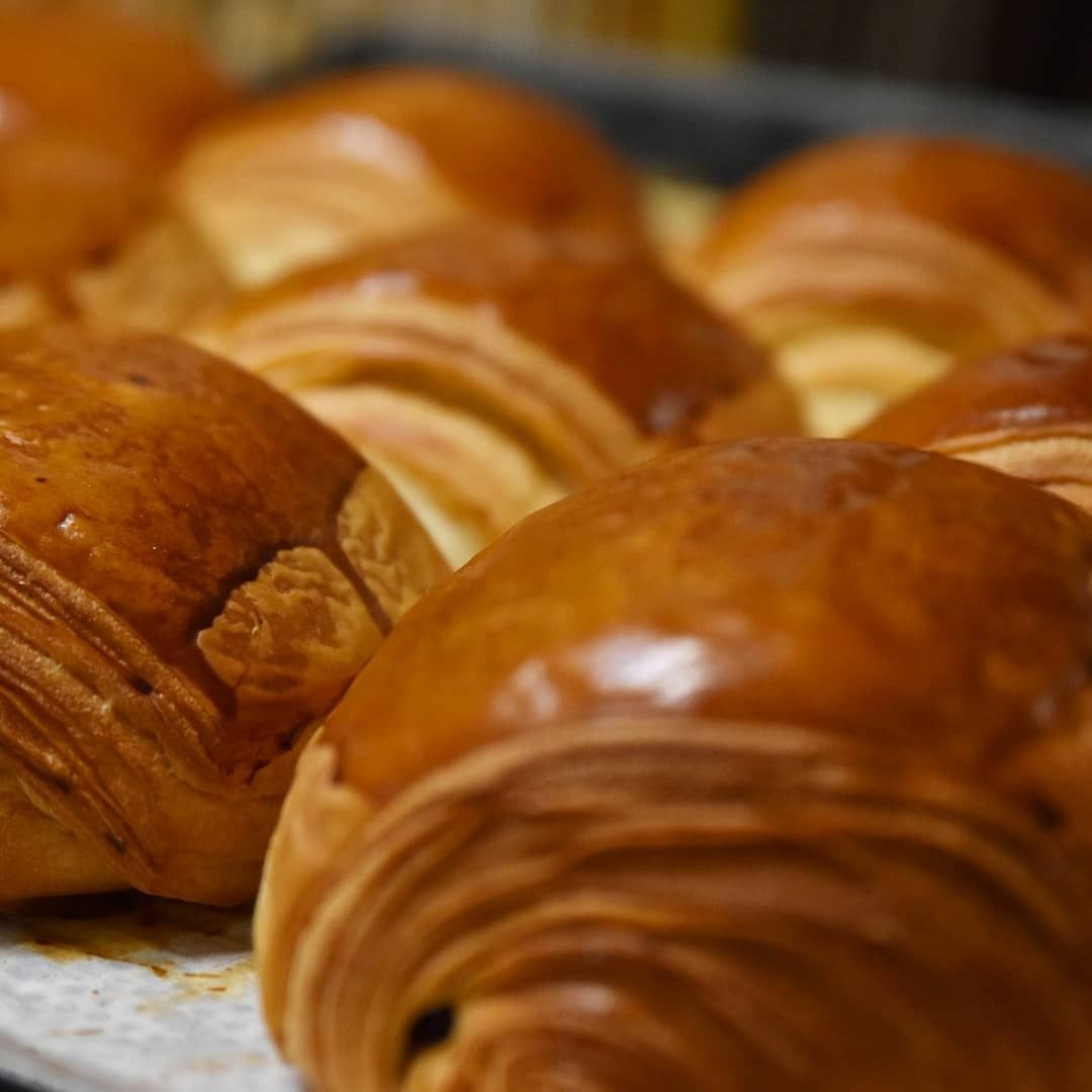 Croissants dorés sur une plaque de cuisson, gros plan mettant en valeur les couches feuilletées.