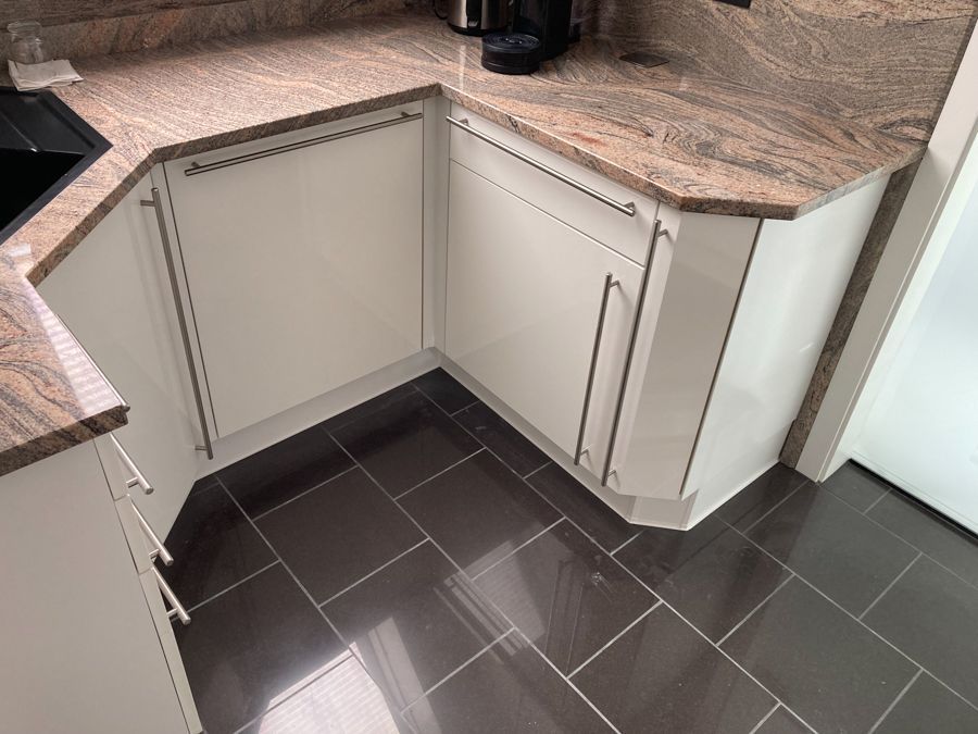 Eine Küche mit weißen Schränken und einer Arbeitsplatte aus Granit.