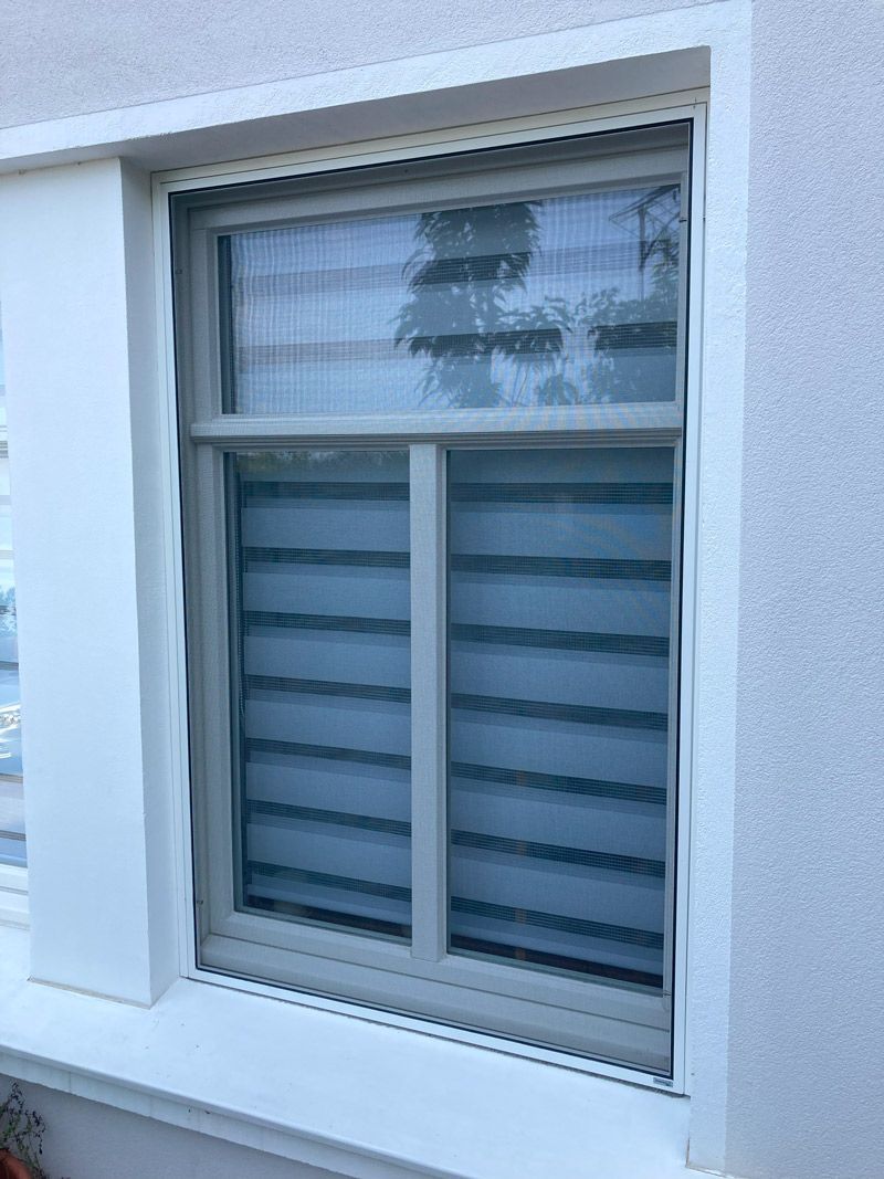 Ein Fenster an der Seite eines Gebäudes mit Fensterläden.