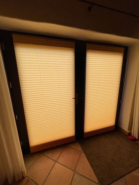 In einer Ziegelwand befindet sich ein weißes Fenster mit einem Fliegengitter.