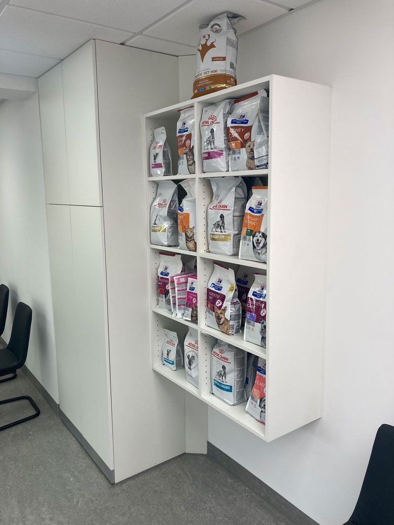 Ein Regal voller Tüten mit Hundefutter in einem Zimmer.