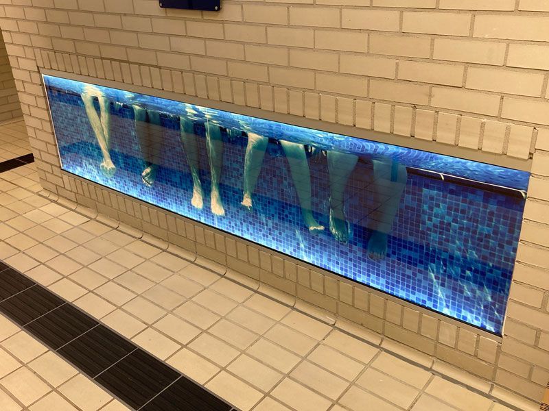 Ein Schwimmbecken mit einem Bild von Menschen, die darin schwimmen