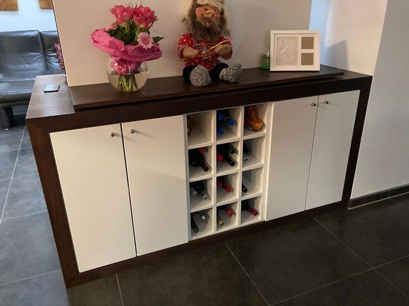 Ein weiß-schwarzer Rezeptionstresen mit einem Stuhl in einem Zimmer.