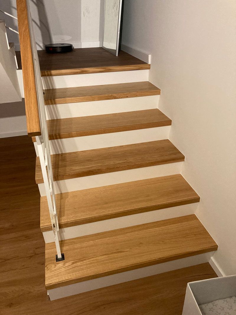 Eine Treppe mit einem Holzgeländer und einem weißen Geländer.