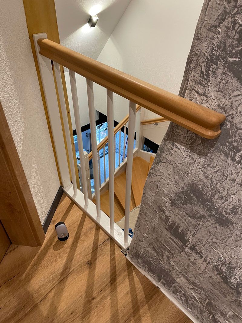 Eine Treppe mit einem Holzgeländer und einem weißen Geländer.