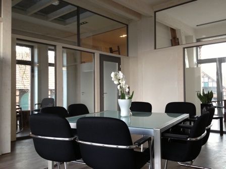 Ein Raum mit einem Tisch und Stühlen und einer Vase mit Blumen