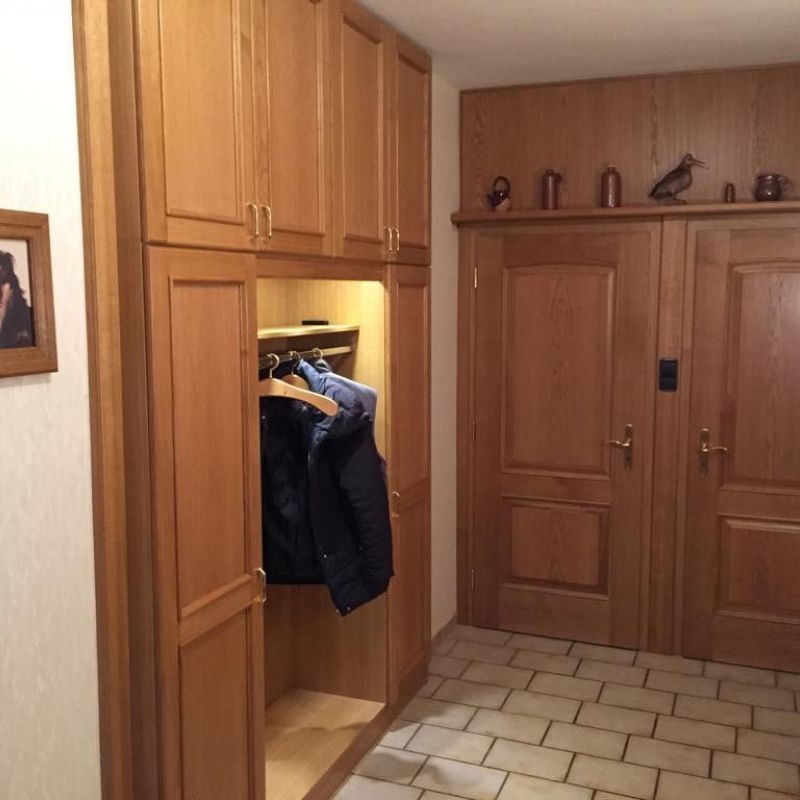 Ein Flur mit Holzschränken und einem Bild an der Wand