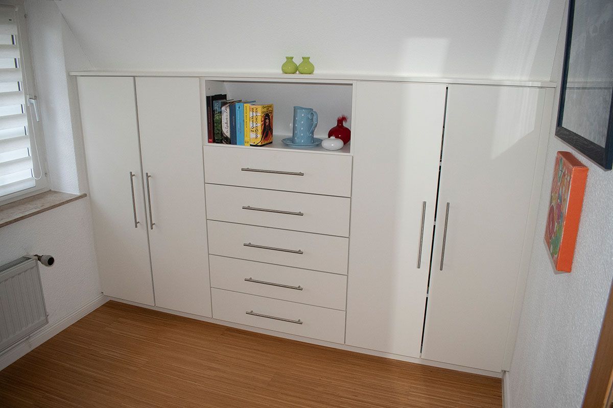 Ein Raum mit vielen weißen Schränken und Schubladen