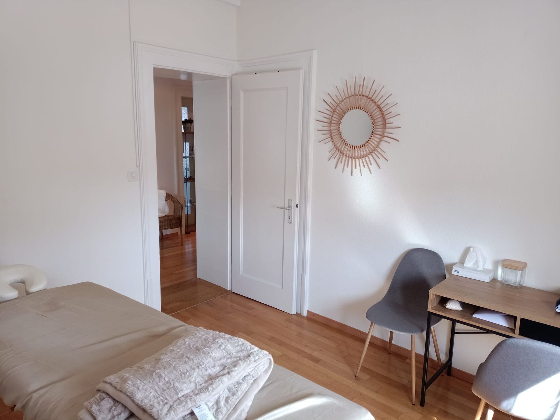 Une chambre avec un lit, un bureau basé à Fribourg, des chaises et un miroir au mur 