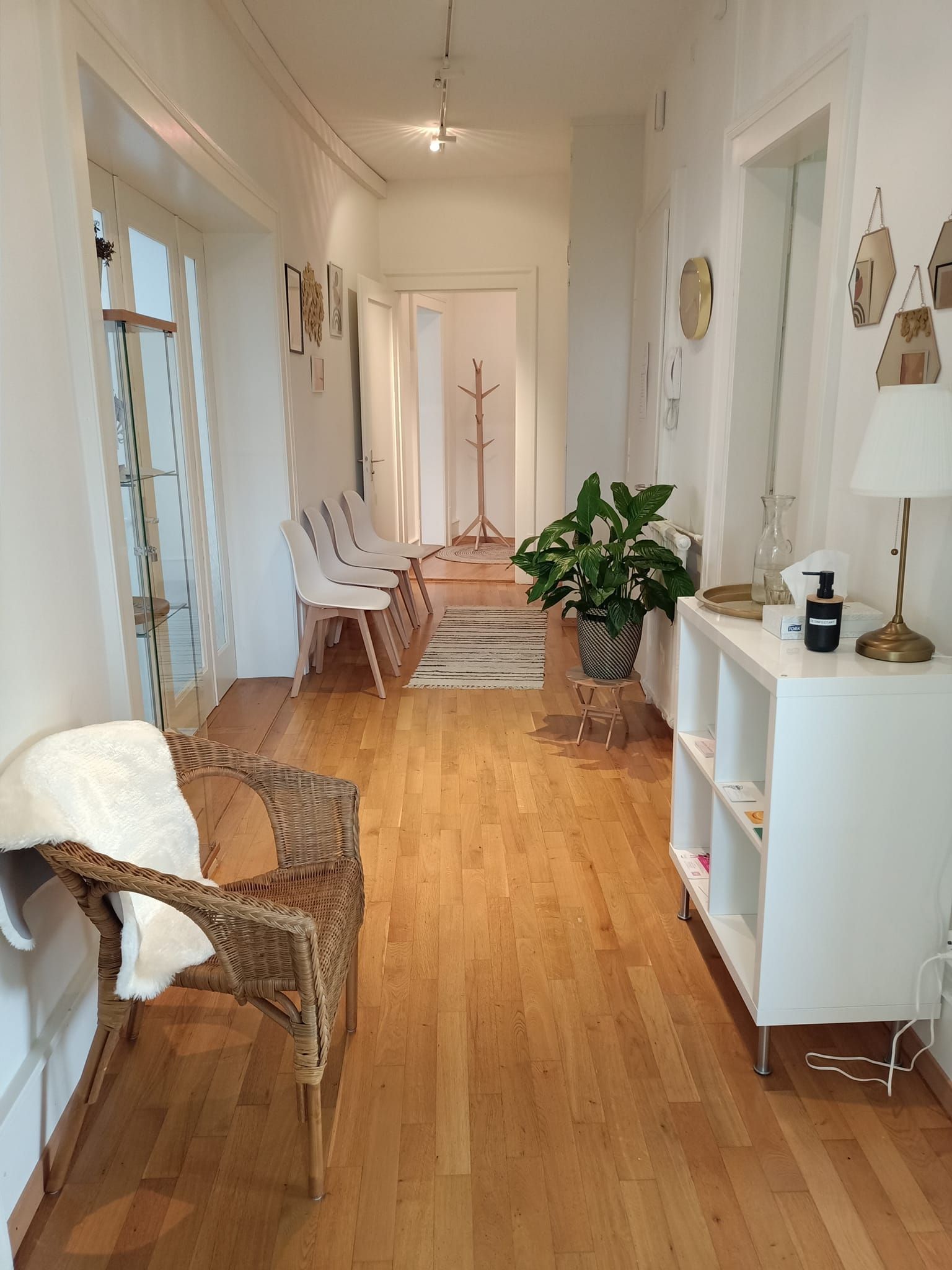 Un long couloir avec parquet et murs blancs dans le bureau basé à Fribourg