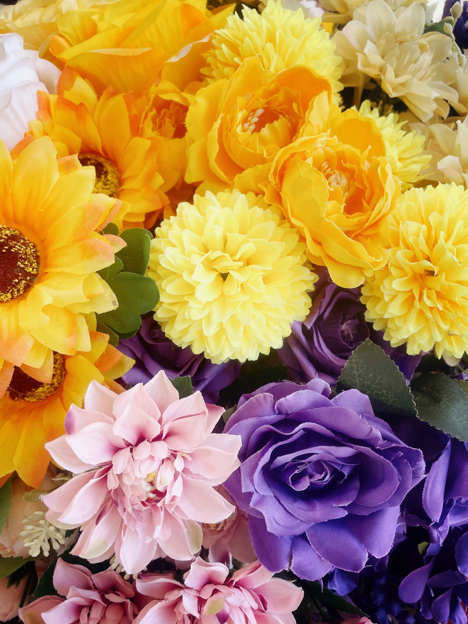 Gros plan d'un bouquet composé de fleurs jaunes, violettes et roses assorties.