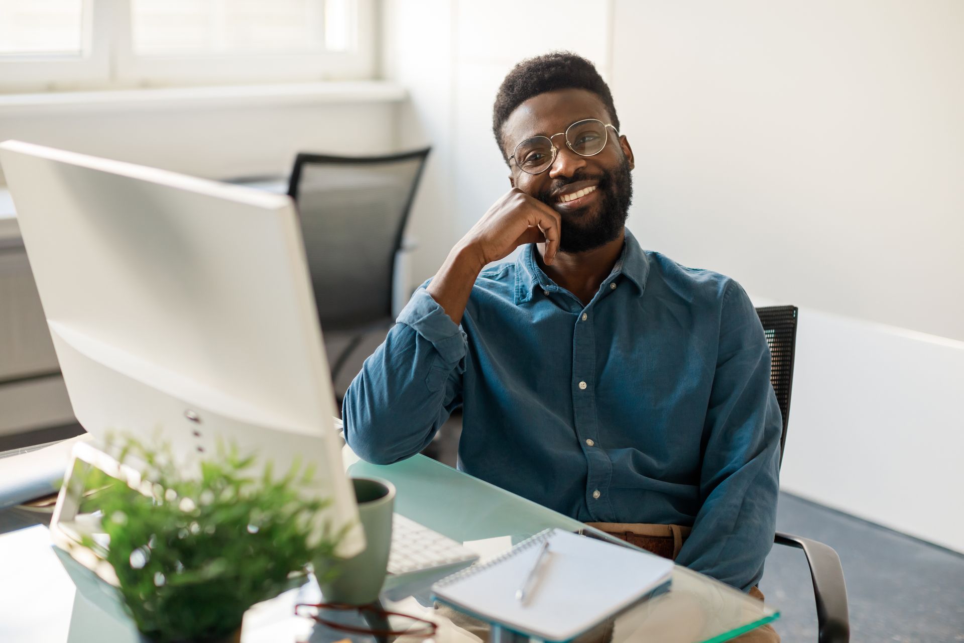 Jeune homme souriant derrière un bureau