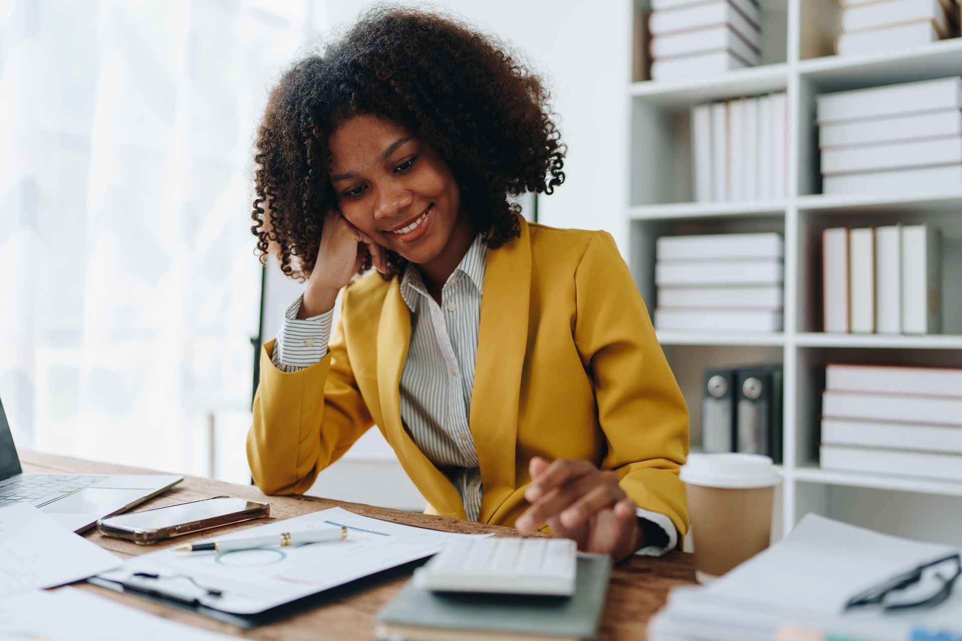 Jeune femme avec veste jaune souriante en regardant des documents