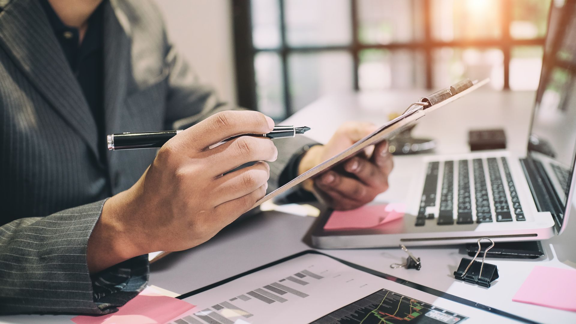 Professionnel tenant un stylo devant un ordinateur