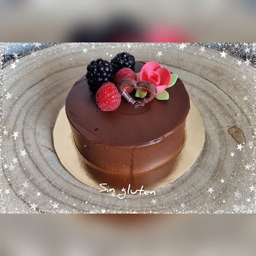 Un pequeño pastel de chocolate con bayas y una rosa encima.