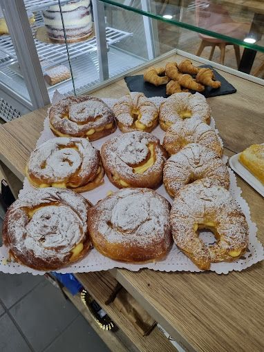 Una bandeja de pasteles cubiertos de azúcar en polvo sobre una mesa de madera.