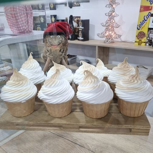 Un montón de cupcakes con glaseado blanco encima.