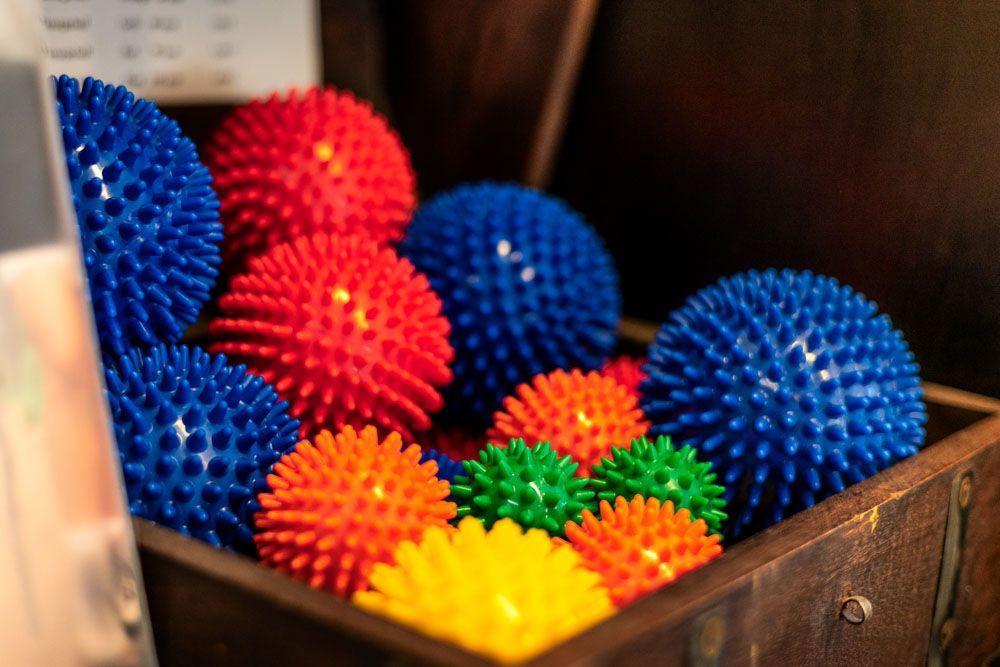 Eine Holzkiste, gefüllt mit verschiedenen bunten, stacheligen Bällen.