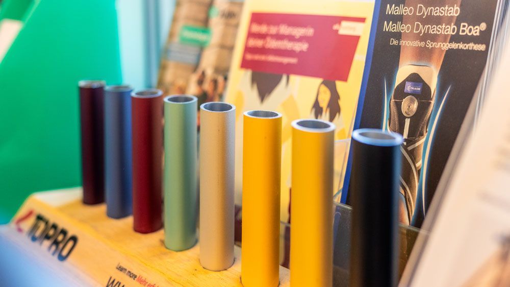 Mehrere Zylinder stehen auf einem Tisch neben einem Buch.