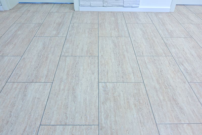 Hellbeige rechteckige Fliesen, versetzt verlegt, in einem Raum.