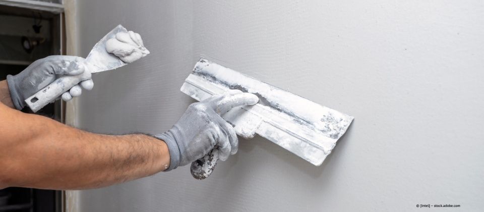 Mitarbeiter von Andreas Lang verputzt Wand