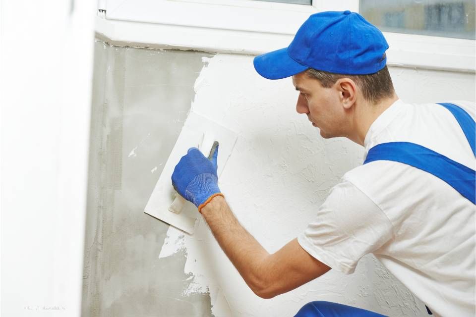 Mitarbeiter von Andreas Lang verputzt Wand
