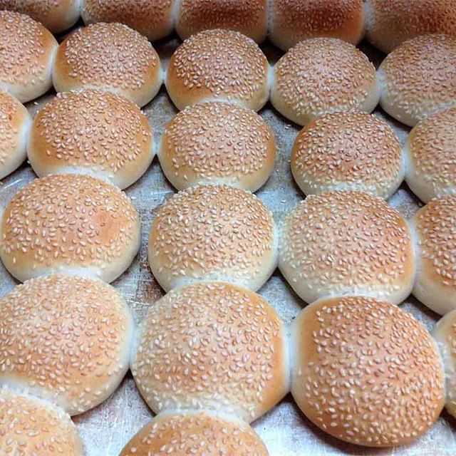 Un montón de bollos con semillas de sésamo encima.