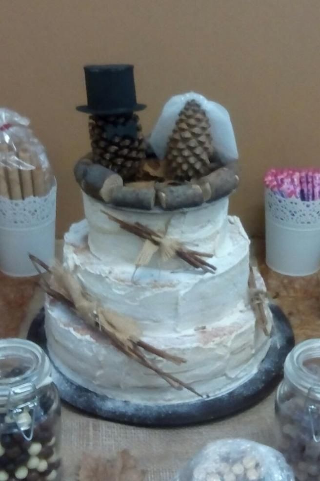 Un pastel de bodas con un sombrero de copa y piñas encima.