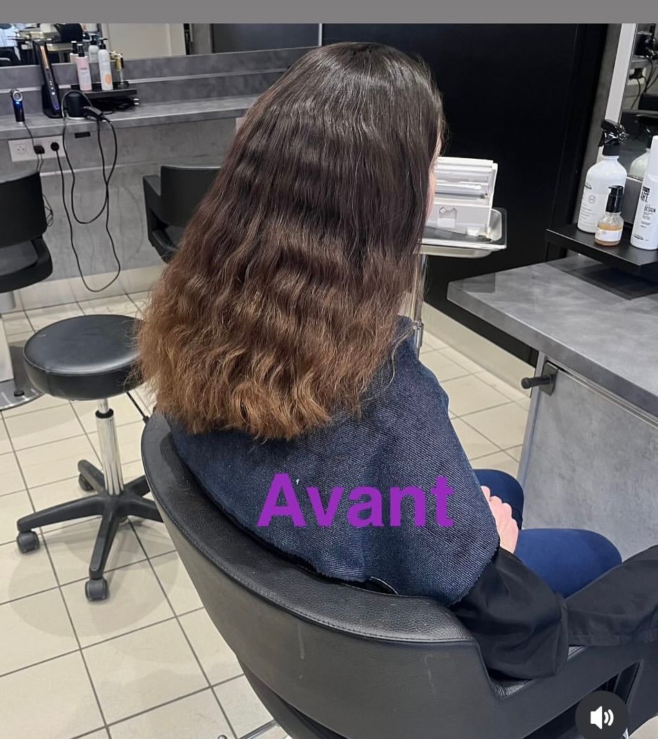 Personne brune assise dans un salon de coiffure.