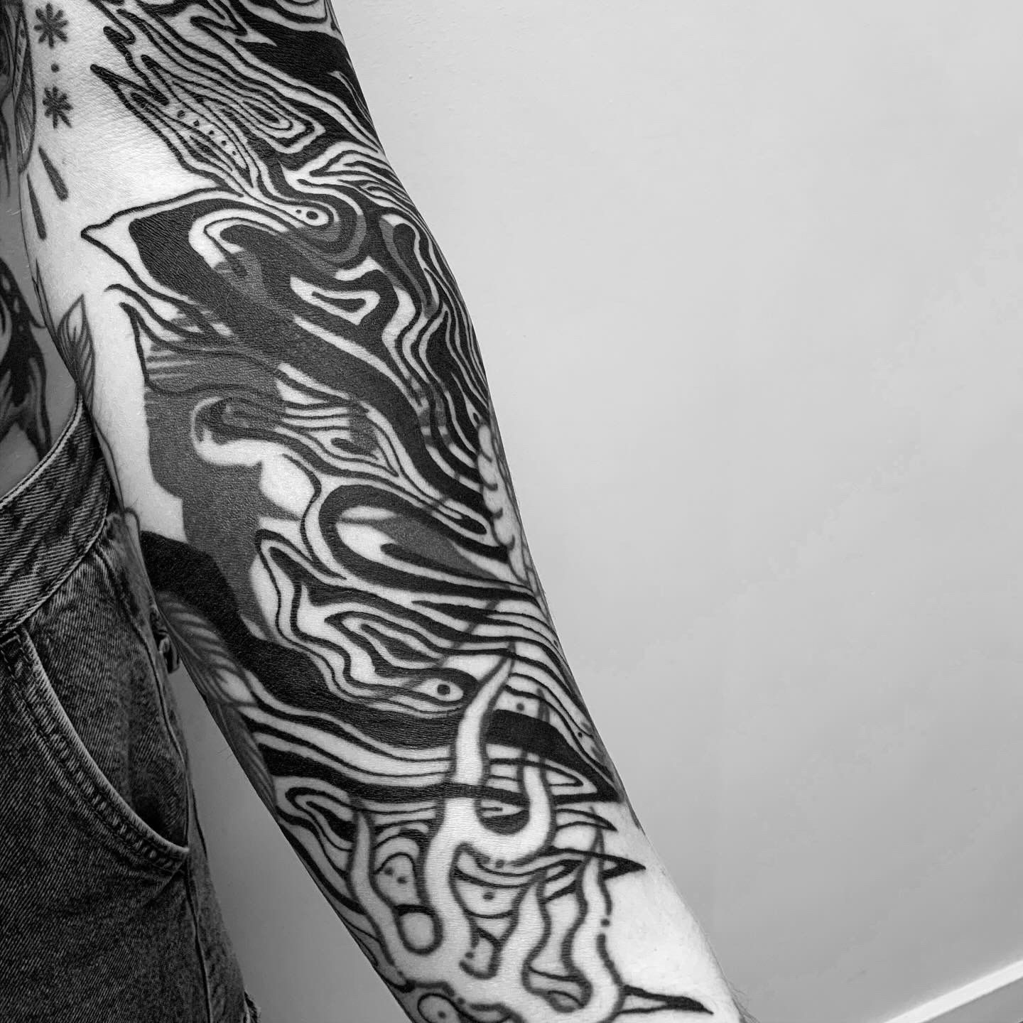 Una fotografía en blanco y negro del brazo de una persona con un tatuaje.