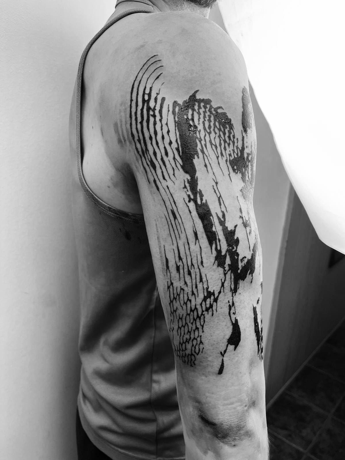 Una fotografía en blanco y negro de una persona con un tatuaje en el brazo.