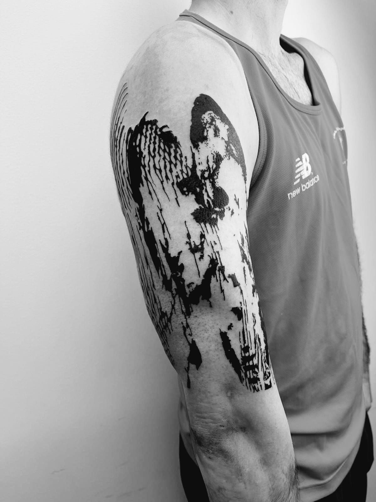 Un hombre con un tatuaje en el brazo lleva una camiseta sin mangas New Balance.
