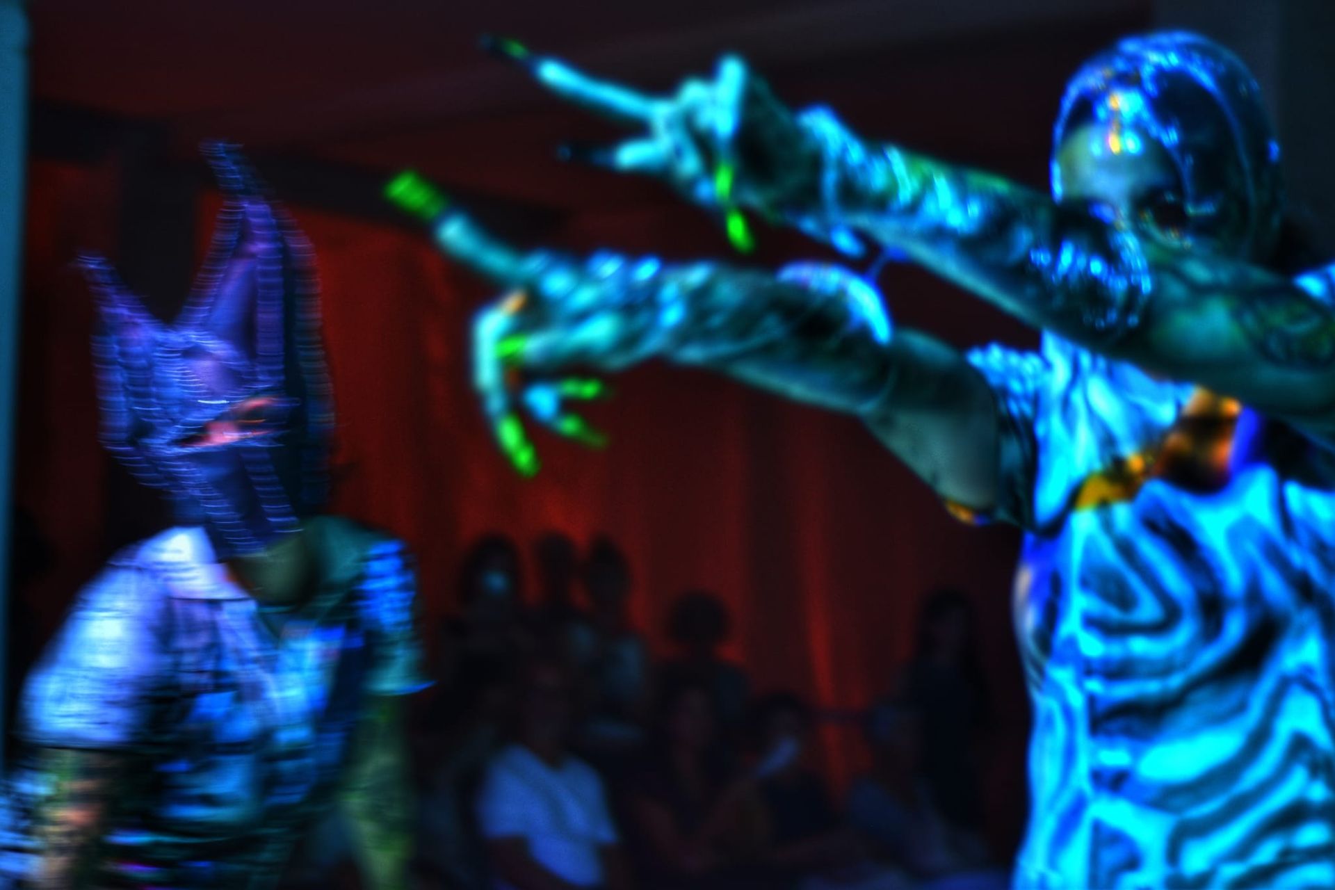 Una imagen borrosa de una persona con pintura que brilla en la oscuridad en su cuerpo.