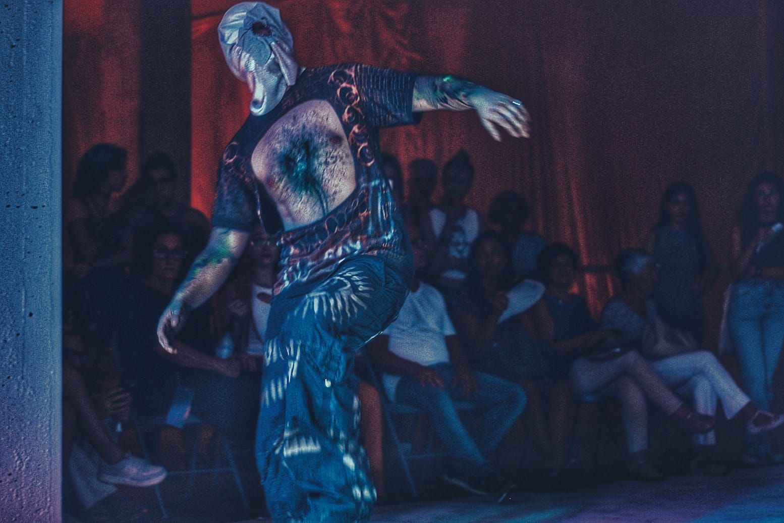 Un hombre con una camisa de lentejuelas está bailando frente a una multitud.