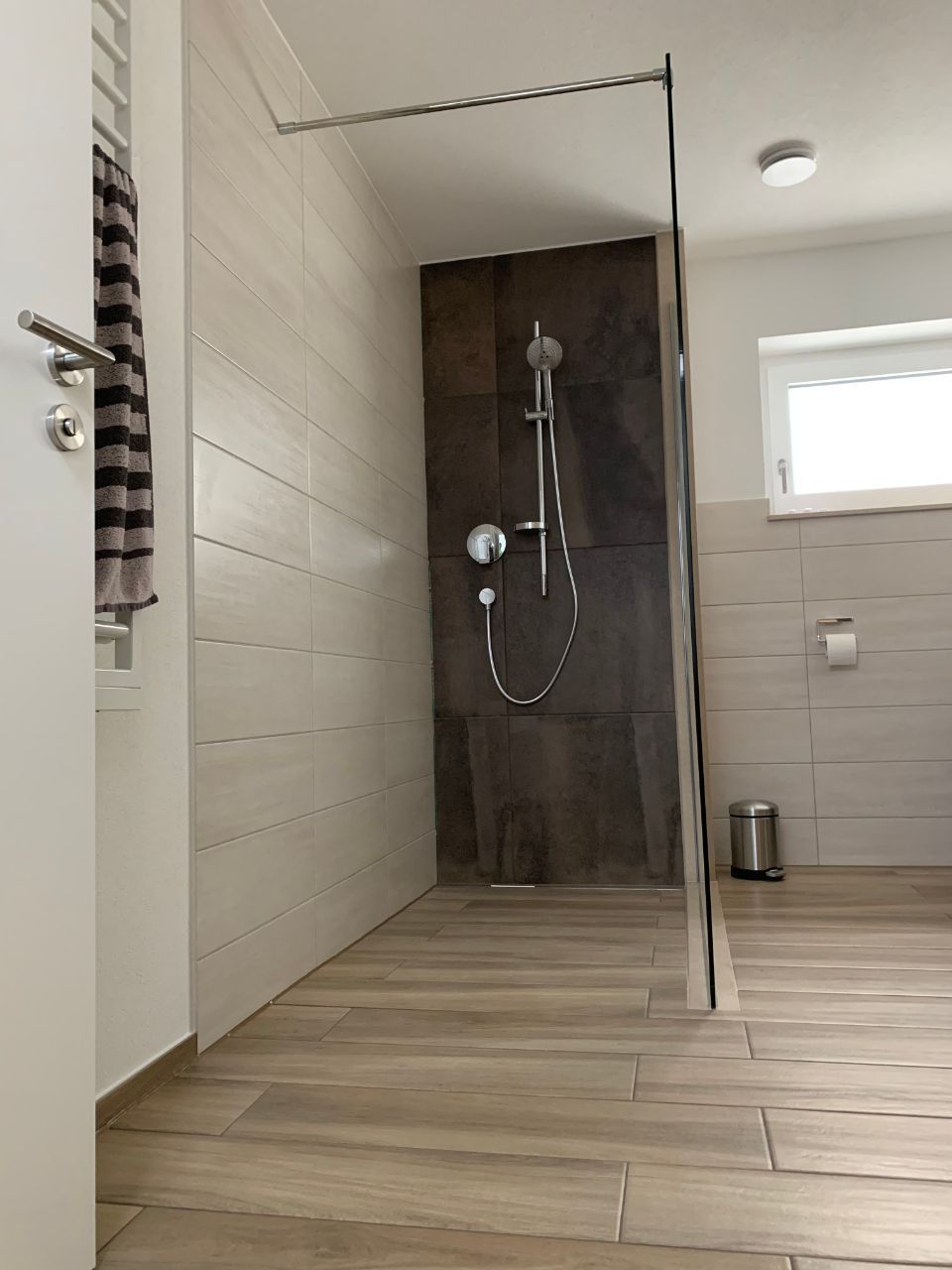 Bodennahe Dusche mit Glaswand und Wand mit Steinplatten