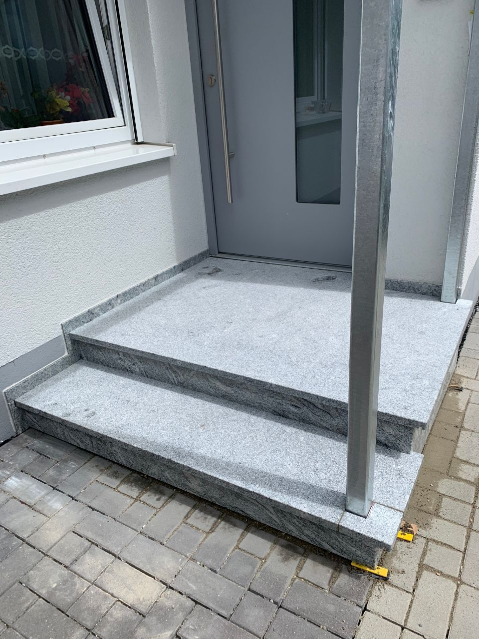 zwei Treppenstufen aus Naturstein an einer Haustür