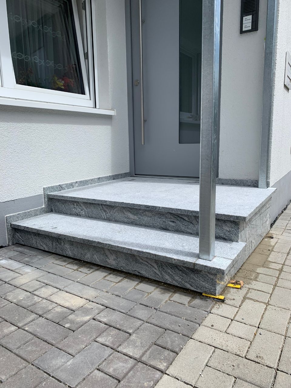 zwei Natursteinstufen an einer Haustür