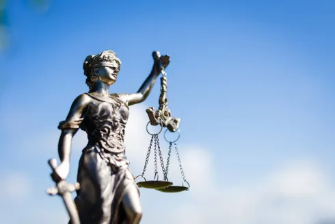 Una estatua metálica de la Dama de la Justicia sosteniendo una espada y una balanza.