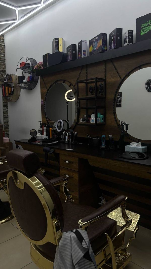 In der Mitte des Raumes steht ein Friseurstuhl. Foto vom Ado Barbershop, Inh. Bijo
