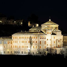 Un gran edificio blanco está iluminado por la noche.