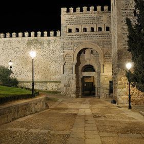 Un muro de piedra con una puerta delante por la noche.
