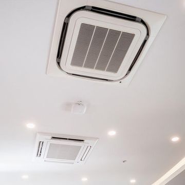 Hay dos aparatos de aire acondicionado en el techo de una habitación.