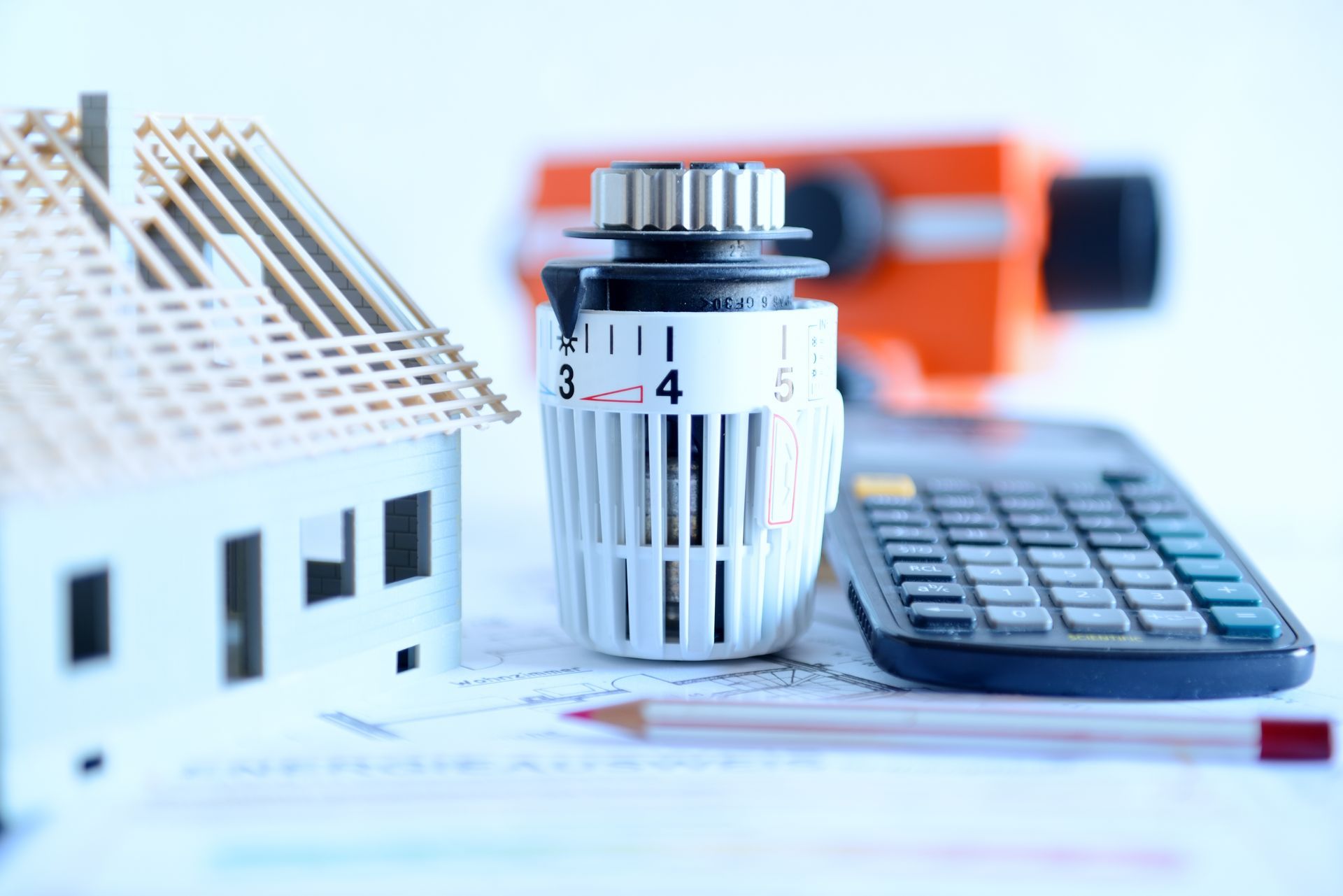 Maquette de maison, thermostat et calculatrice
