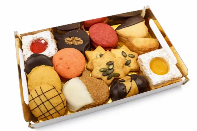 Tres galletas de almendras y caramelo con pasas sobre una superficie blanca.