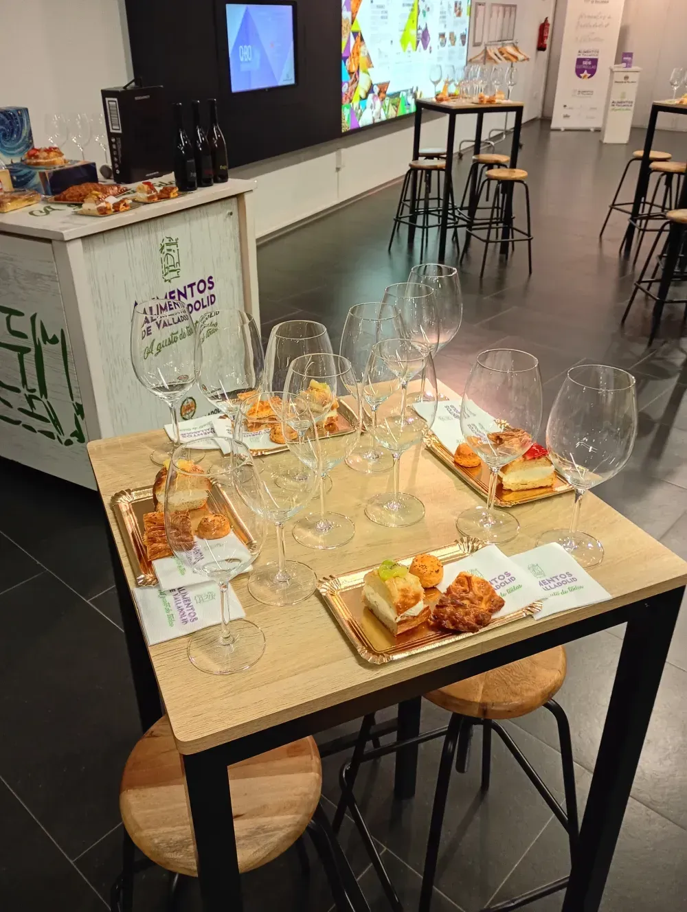 Espolvoreando a mano azúcar glas sobre cupcakes glaseados cubiertos con frutas y flores.