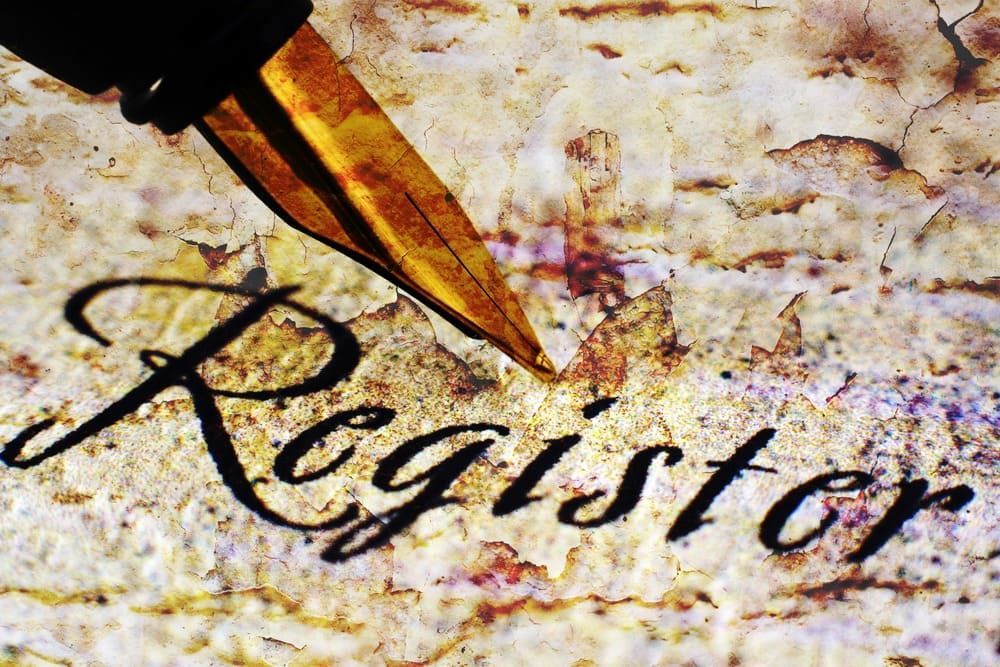Una pluma estilográfica está escribiendo la palabra registrar en un trozo de papel.