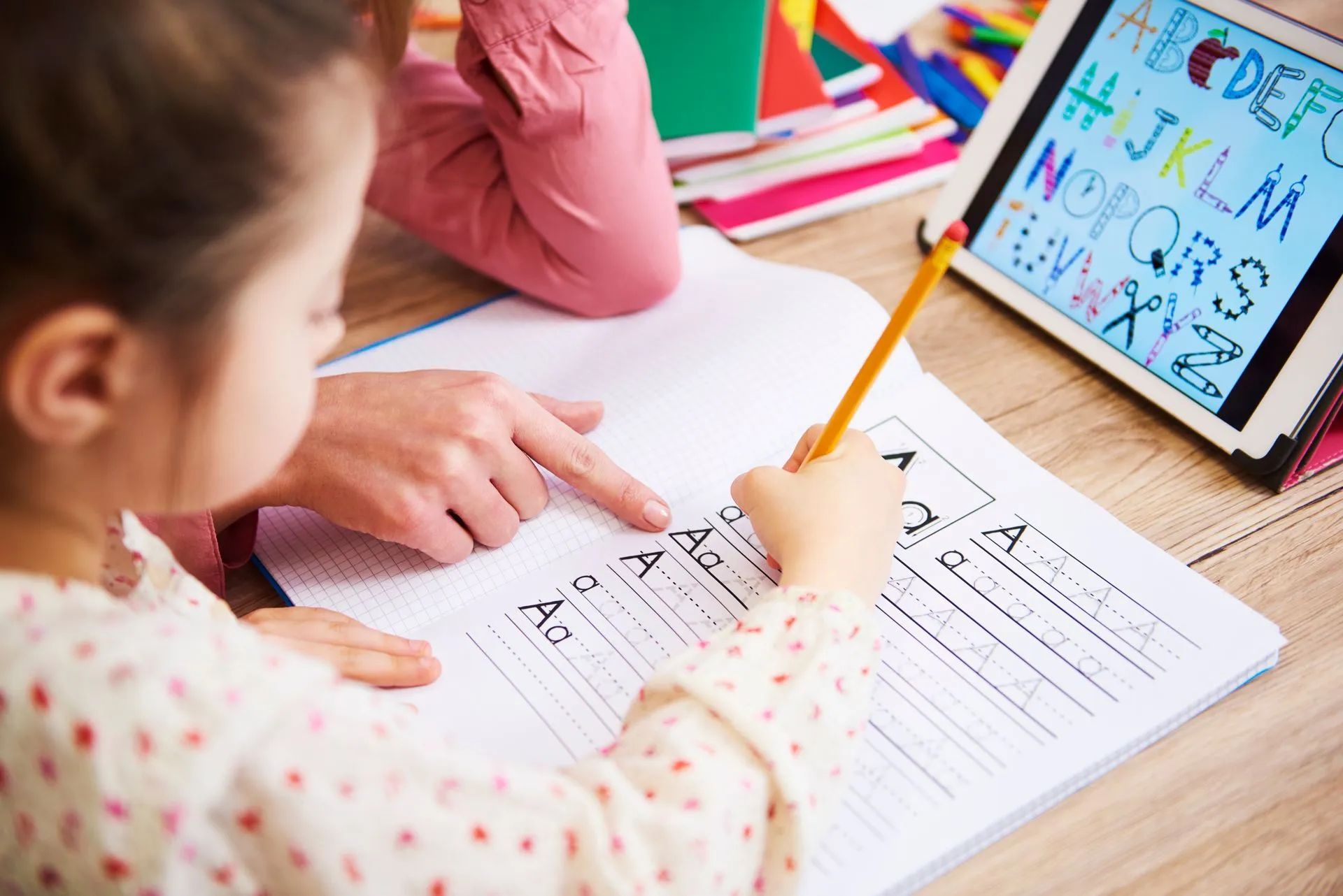 Une petite fille apprend à écrire grâce à une tablette numérique
