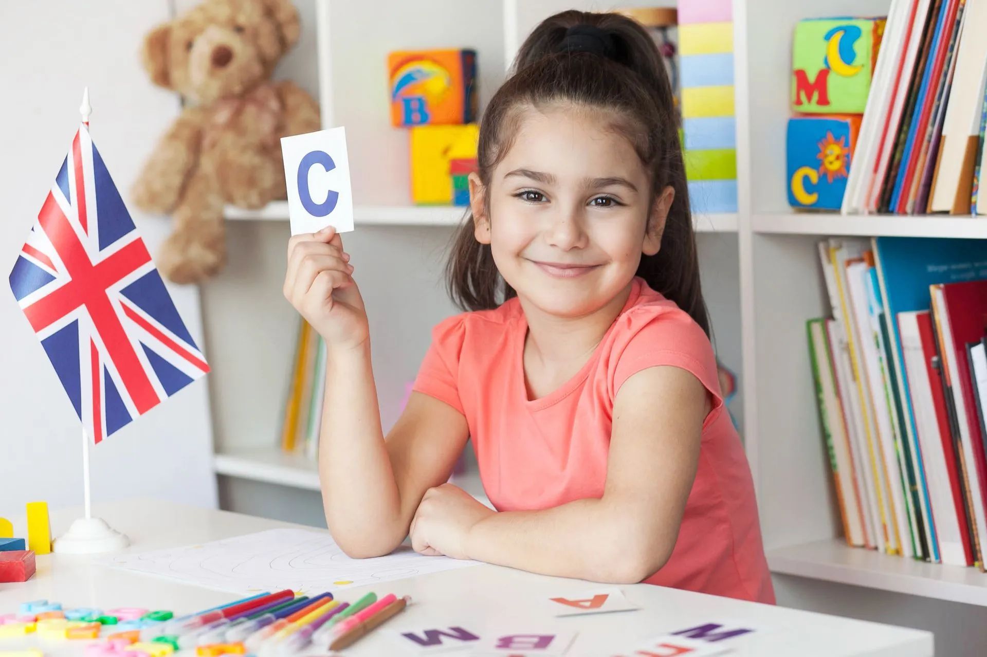 Petite fille montrant la lettre C en cours d'anglais