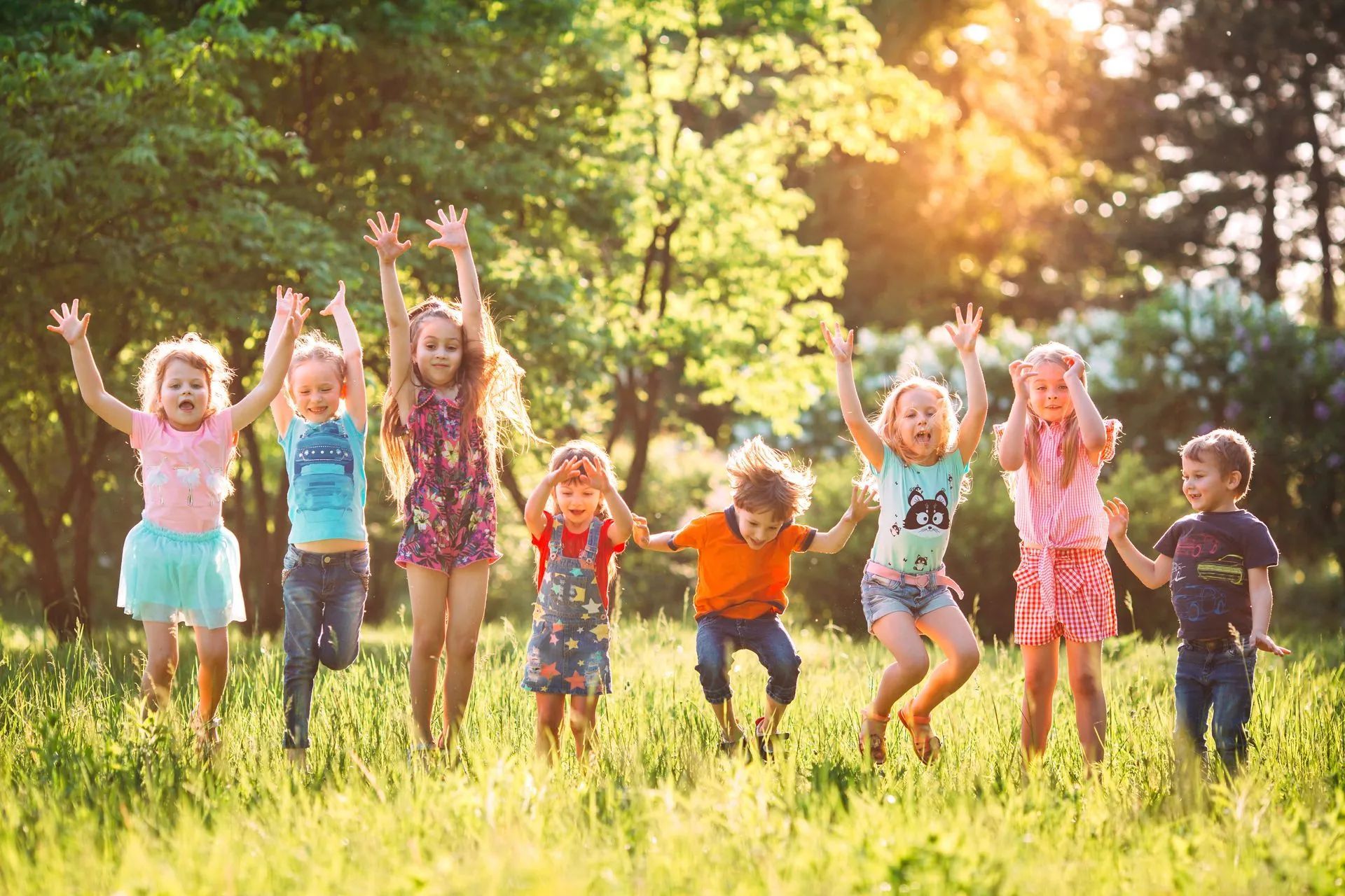 Groupe d'enfants sautant en l'air dans un parc