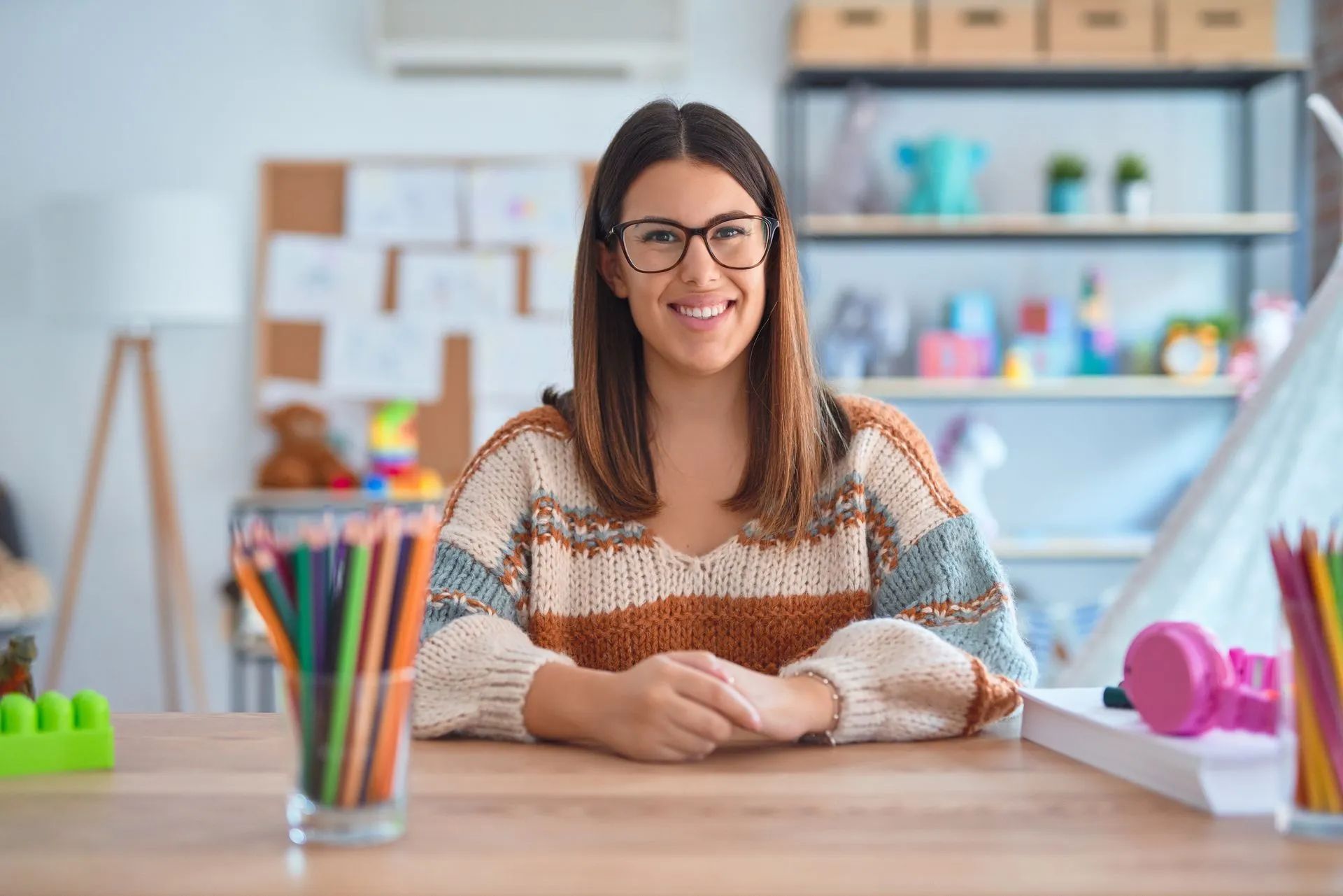 Jeune femme assise les mains croisées à un bureau